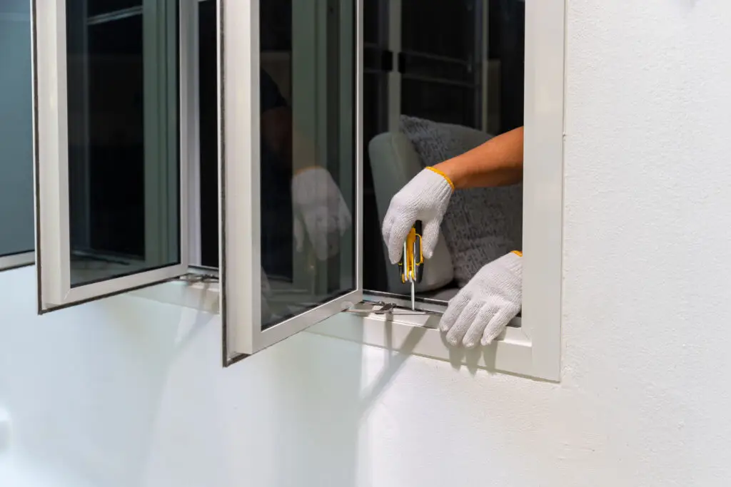 Contractor installing window in the front of a home
