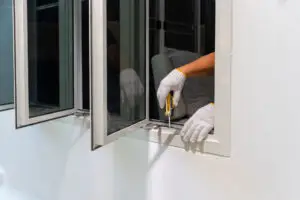 Contractor installing window in the front of a home