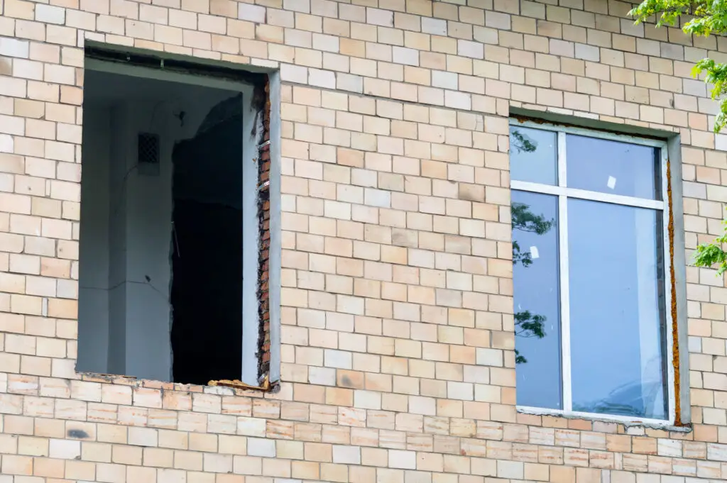 A missing window in the front of a brick sided home needing to replace a front window